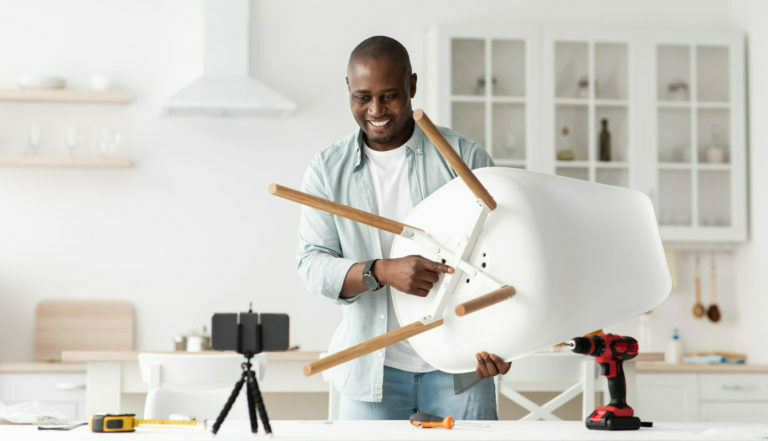 Blog about carpentry and repairs. Positive african american handyman showing finished chair to